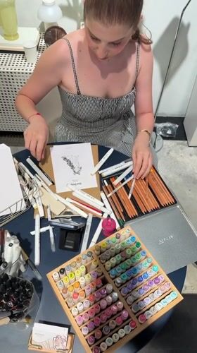 Art supplies out, drawing in progress at a Tel Aviv table