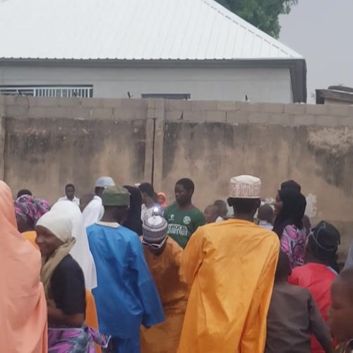 Community gathering observed outside building in Bauchi, Nigeria