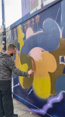 Man spray-paints mural on London wall Friday evening