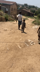 Three boys walk together on rural Nigeria road