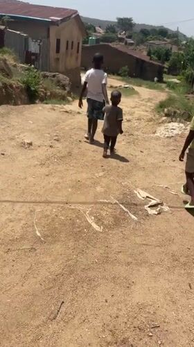 Three boys walk together on rural Nigeria road