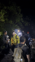 Nighttime group gathering with headlamps in Indonesian woods