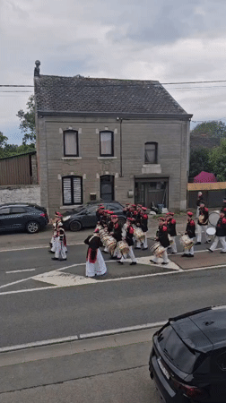 Marching band parade proceeds through Belgian village streets