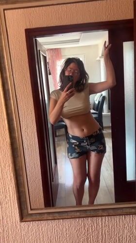 Woman takes mirror selfies in Podgorica home, cat meows