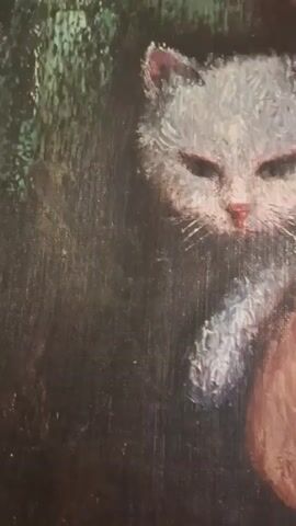The video shows a close-up of an oil painting of a white cat with green eyes. The cat is looking towards the viewer with its mouth slightly open. The background is dark and appears to be a forest. The painting is detailed and realistic, with a focus on the cat's fur and facial features.