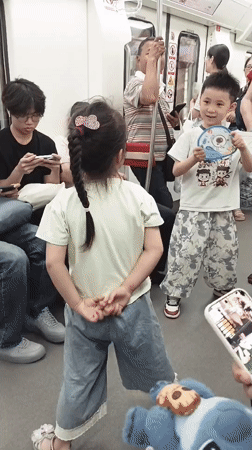 Children dance on moving subway car in Shapingba District