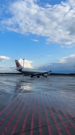 Wet tarmac and parked jets at Minsk Airport on a stormy afternoon