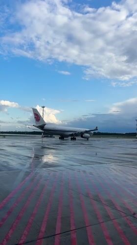 Wet tarmac and parked jets at Minsk Airport on a stormy afternoon