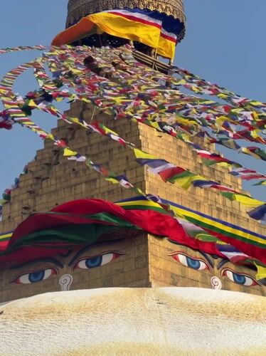 Golden Buddhist stupa photographed against blue sky in Kathmandu