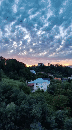 Sochi hillside neighborhoods at sunset, clouds rolling in