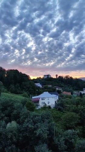Sochi hillside neighborhoods at sunset, clouds rolling in