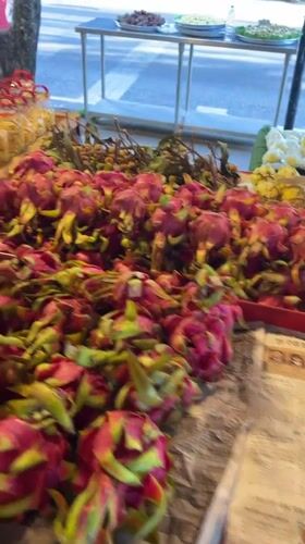 Fruit vendor serves customers at Thai market stand