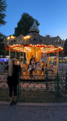 Twilight carousel lights illuminate Tbilisi fairground during evening hours