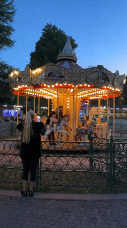 Twilight carousel lights illuminate Tbilisi fairground during evening hours