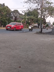 Everyday traffic moving through a road junction in Badas, Indonesia
