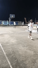 Outdoor nighttime hangout — basketball and a rocky gathering spot.
