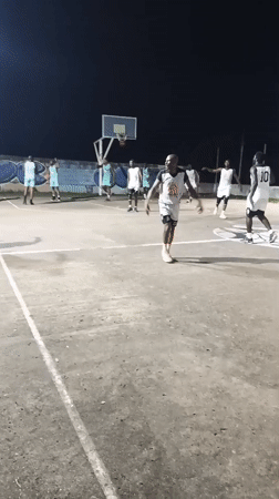 Outdoor nighttime hangout — basketball and a rocky gathering spot.