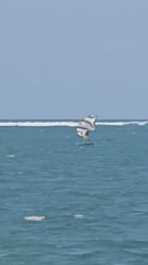 Kitesurfers and jet skis share a breezy Bali coastline