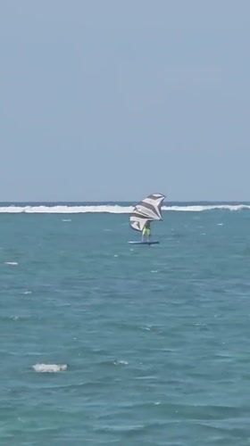 Kitesurfers and jet skis share a breezy Bali coastline