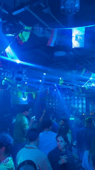Packed indoor venue with international flags and low lighting