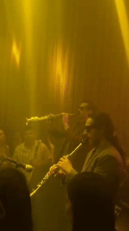 Musicians perform with clarinets in dimly lit Madrid venue