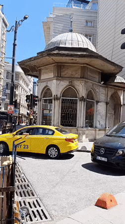 Trams and taxis navigate a busy Istanbul street on a sunny morning