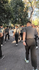 Military group runs outdoor PT session on a tree-lined path in Indonesia