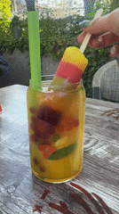 Person enjoys popsicle and fruit drink at Plovdiv café