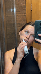 Woman brushes teeth in Donji Pobori bathroom Monday evening