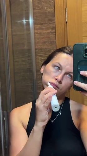 Woman brushes teeth in Donji Pobori bathroom Monday evening