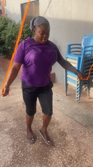 Woman exercises with jump rope in Jos courtyard during morning