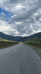 Mountain road filmed through Russian valley under dramatic skies