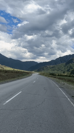 Mountain road filmed through Russian valley under dramatic skies