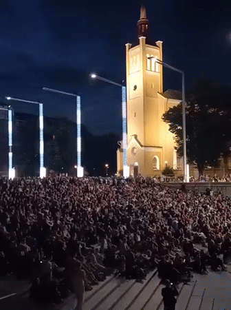 Nighttime crowd gathers at illuminated Tallinn historic venue