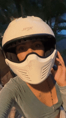 Motorcyclist takes selfie on wet Bali street after rain