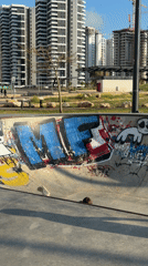 Young person rides scooter at graffiti-covered skate park in Bat Yam