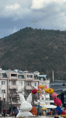 Easter decorations displayed in Blagoevgrad beneath cross-topped hill