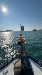 Boat travels through calm waters near Rawai, Thailand