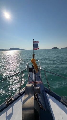 Boat travels through calm waters near Rawai, Thailand