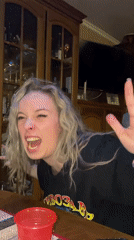 Woman makes playful faces at table in Abakan