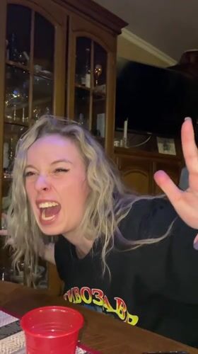 Woman makes playful faces at table in Abakan