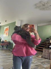 Woman takes mirror selfies with gray cat in Russian home