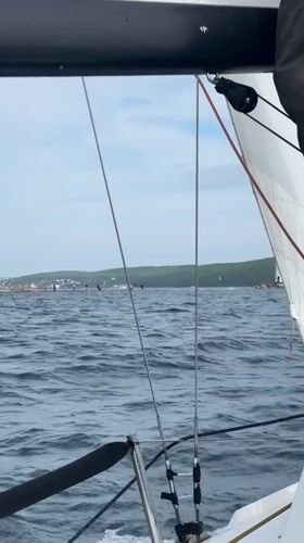 Boat sails past lighthouse in choppy Vladivostok waters
