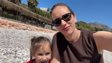 Woman and girl share smiling moment on Turkish beach