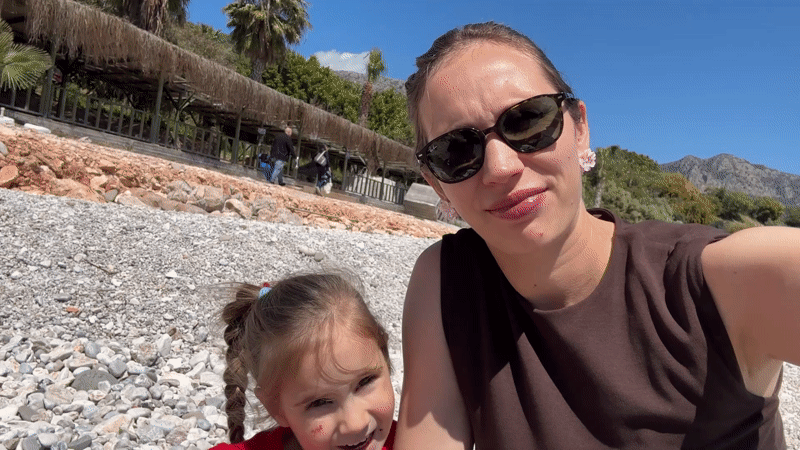 Woman and girl share smiling moment on Turkish beach
