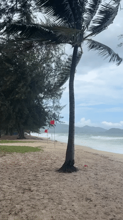 Rough surf and warning flags on a stormy Choeng Thale beach