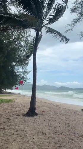 Rough surf and warning flags on a stormy Choeng Thale beach