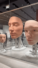 Mechanical mannequin heads displayed behind glass in Dubai