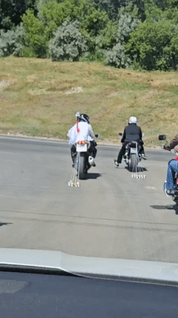 Motorcyclists cruise a tree-lined road in Ulyanovsk