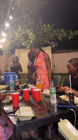 Young women celebrate at nighttime outdoor party in Nigeria
